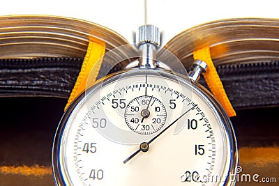 mechanical analog stopwatch on the background of an open book. Time part precision. Speed â€‹â€‹Interval Measurement Stock Photo